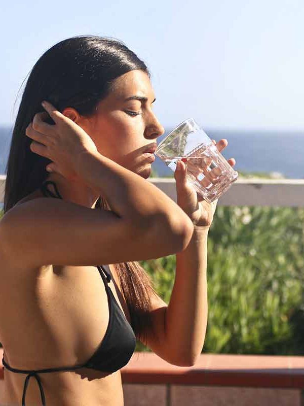 girl in bikini drinking glass of water