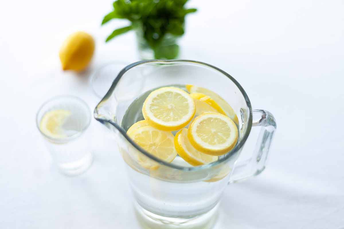 pitcher of water with sliced lemons